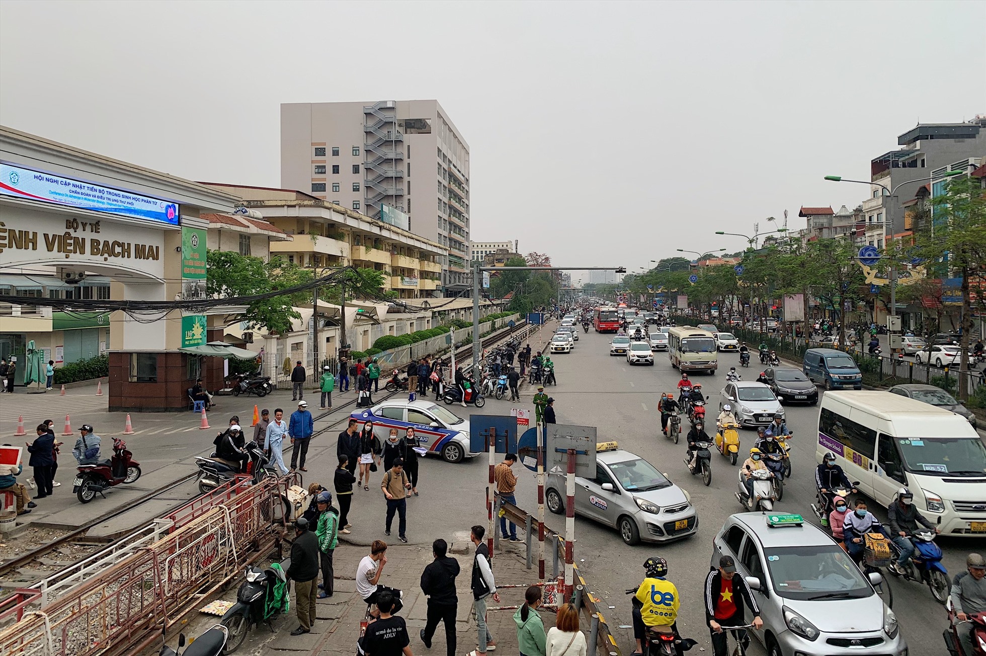 Cổng chính BV Bạch Mai đường Giải Phóng luôn bị xe ôm, taxi trực chờ sẵn để đón khách, dù có lực lượng chức năng.