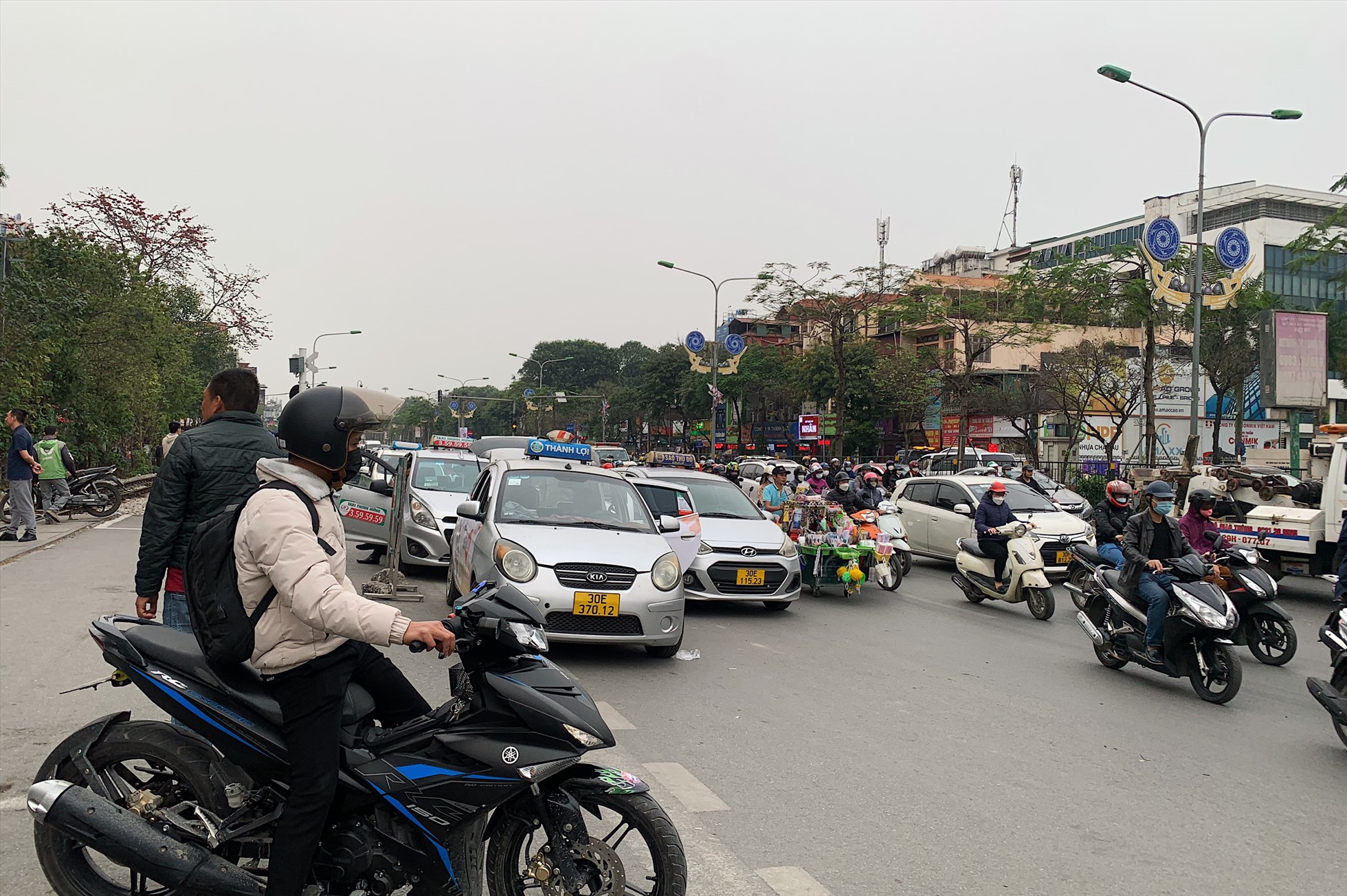 Taxi dàn hàng 2, 3 tại cổng Bệnh viện Bạch Mai ngay khó khăn cho dòng phương tiện trên đường Giải Phóng.