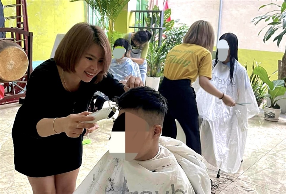 Chị Thủy tham gia cắt tóc cho các bạn nhỏ. Ảnh: Nguyễn Linh