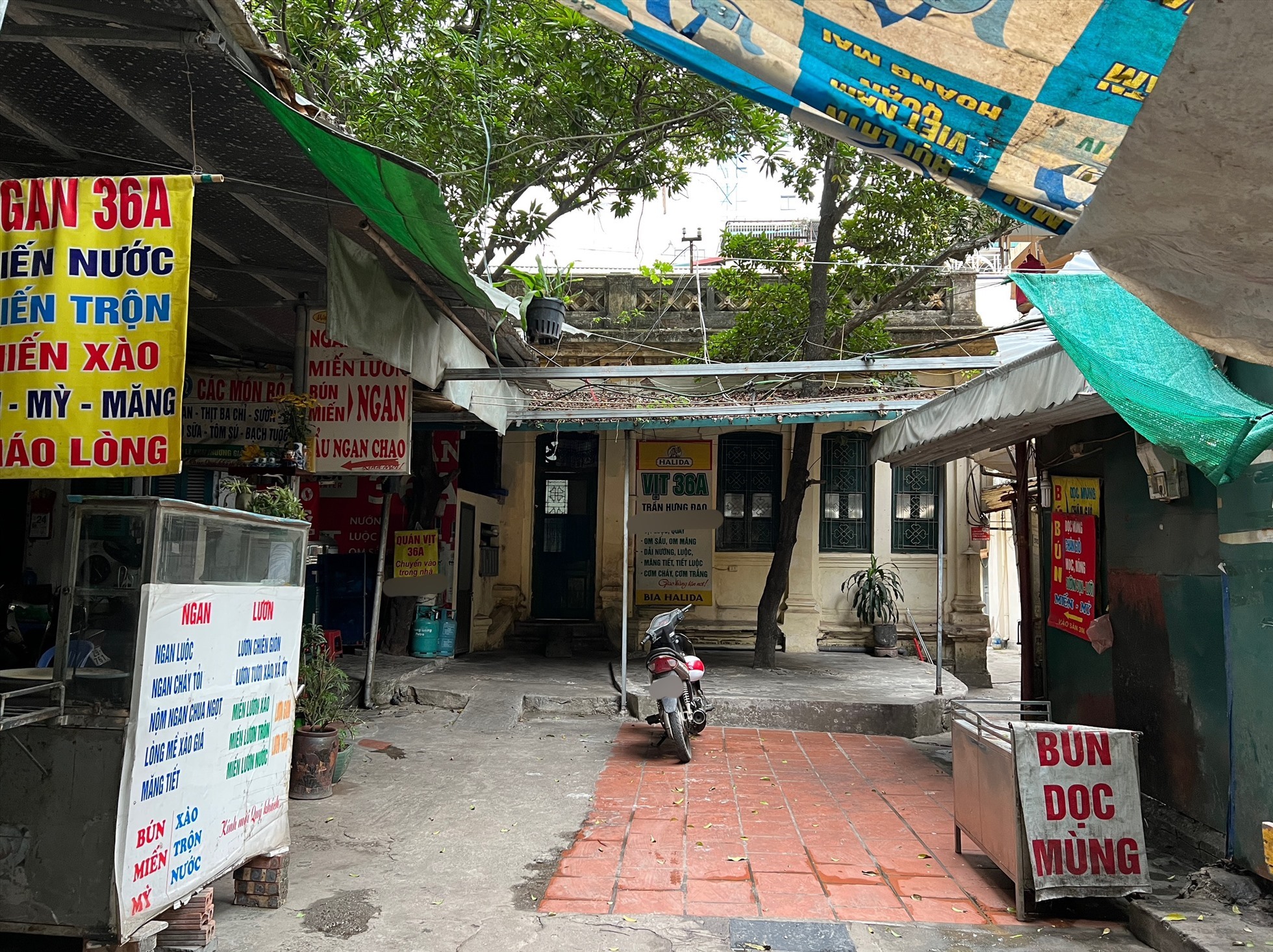 Nhiều người dân tận dụng việc bỏ không đã căng mái tạm che nắng mưa để bán hàng. Ảnh: Nguyễn Thúy.