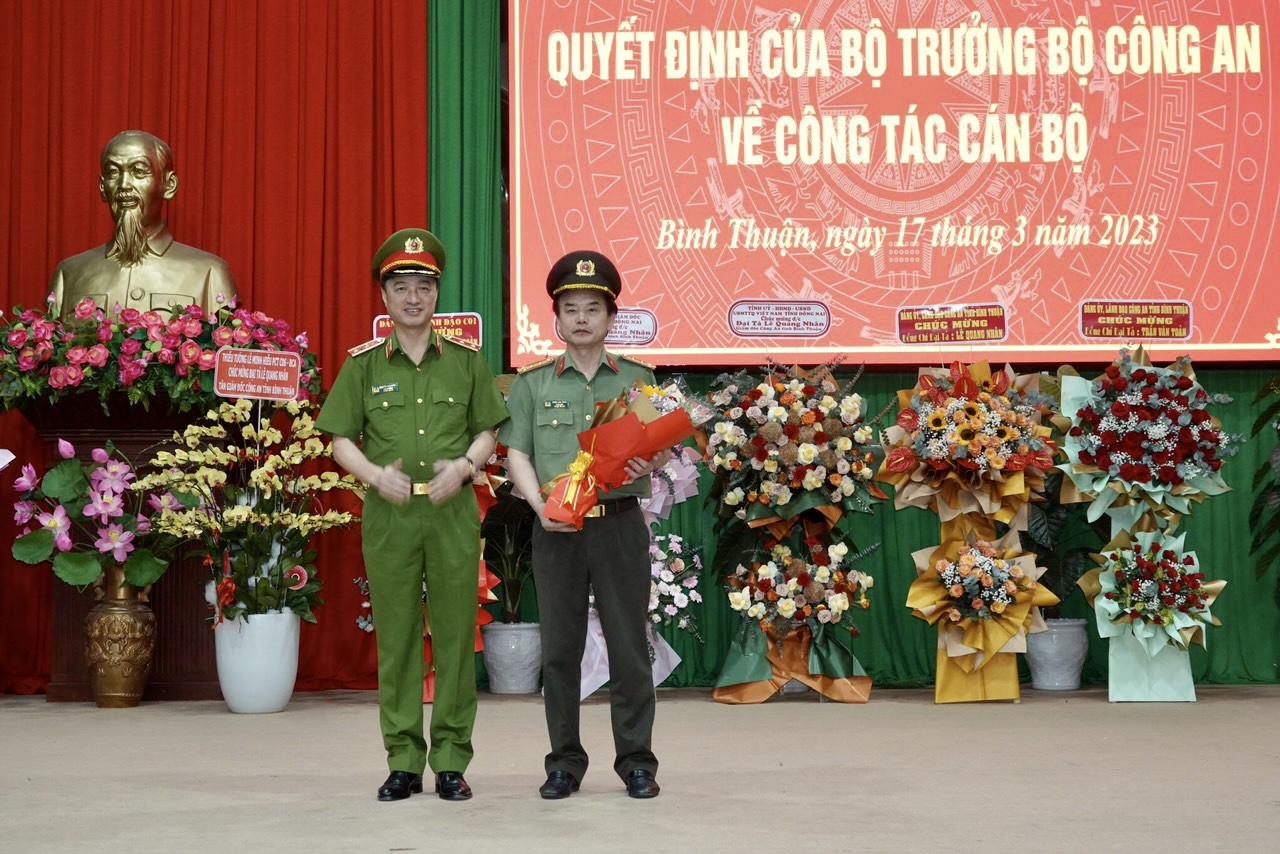 Thứ trưởng Nguyễn Duy Ngọc trao hoa chúc mừng đại tá Trần Văn Toản. Ảnh: Bích Thuận