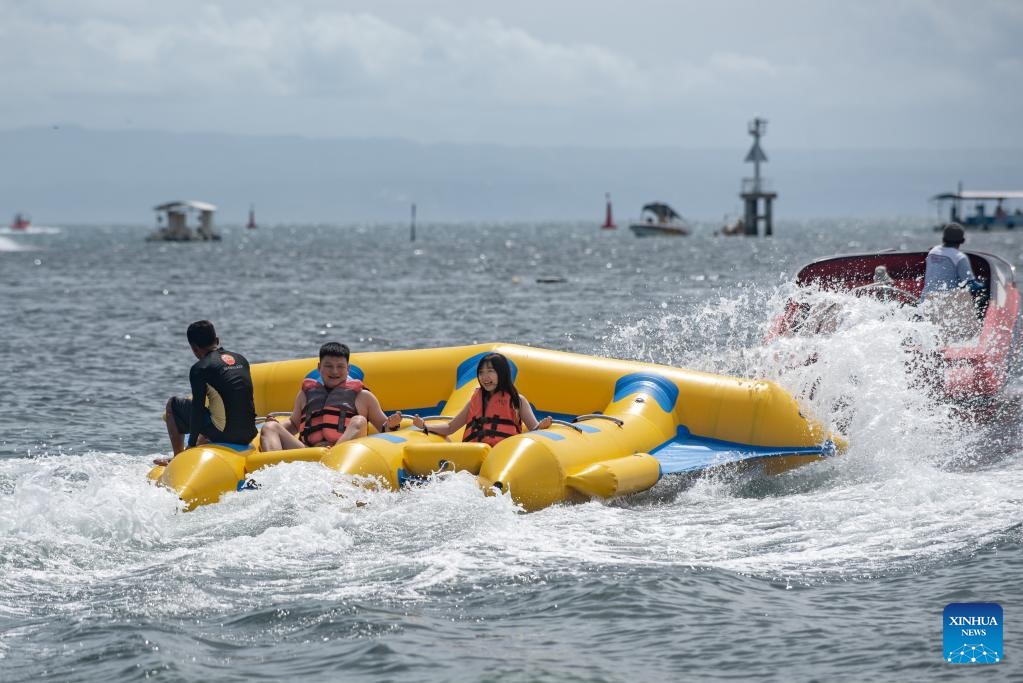 Khách Trung Quốc chơi các trò giải trí trên biển tại vịnh Benoa, Bali, Indonesia ngày 13.2.2023. Khoảng 1.000 khách Trung Quốc đã đến Bali kể từ 22.1 - khi hòn đảo nổi tiếng của Indonesia mở cửa đón khách Trung Quốc trở lại với đường bay charter Thâm Quyến - Bali. Ảnh: Xinhua