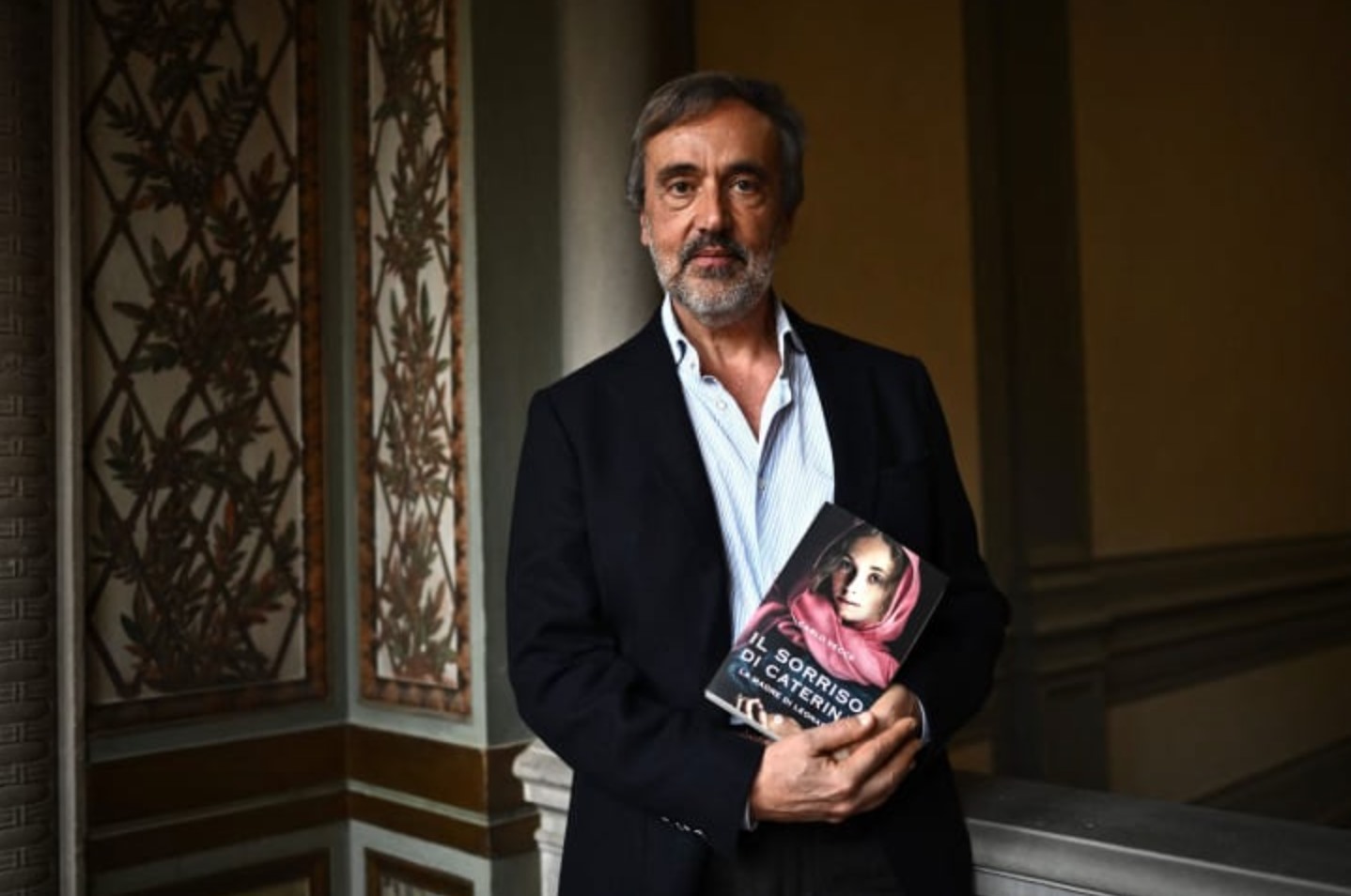 Giáo sư Carlo Vecce và cuốn sách “Il Sorriso di Caterina” (Nụ cười của Caterina) tại Villa La Loggia ở Florence, Italia, ngày 14.3.2023. Ảnh: AFP