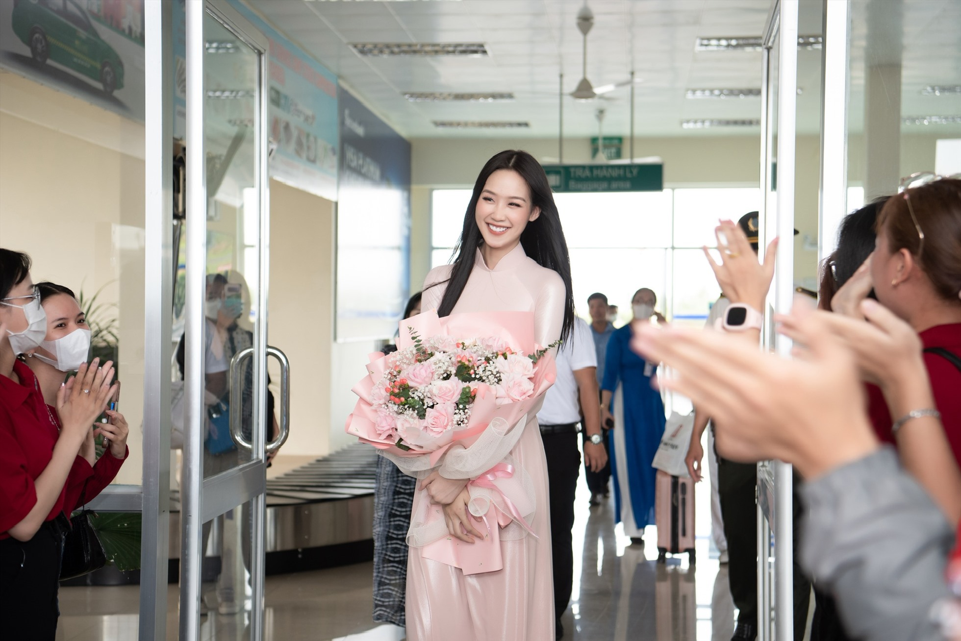 Xuất hiện tại sân bay, nàng hậu gây thiện cảm khi diện áo dài truyền thống màu hồng nhạt nhẹ nhàng. Ảnh: Sen Vàng.