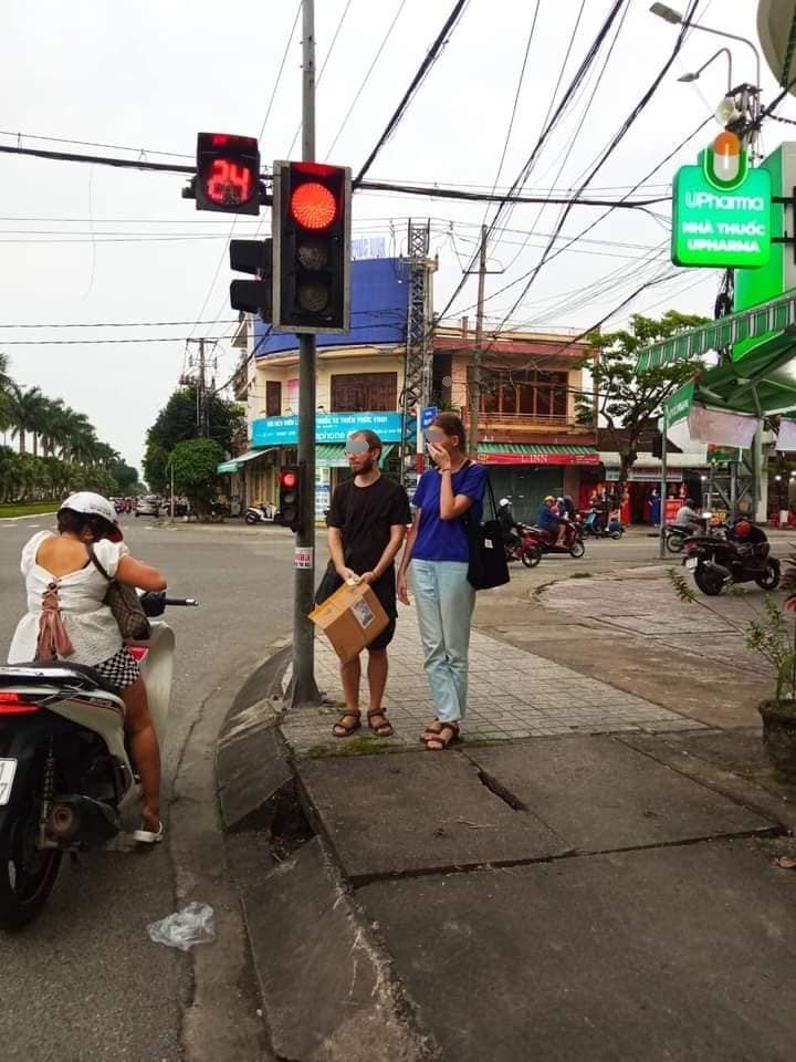 2 du khách người Nga cầm bảng xin cứu giúp ở đường phố Tam Kỳ, Quảng Nam. Ảnh Hoàng Bin.