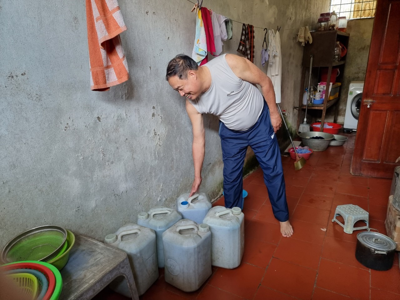 Người dân xóm Kim Chi (xã Nghi Ân) phải dùng can đi mua nước máy từ nơi khác về sử dụng. Ảnh: Quang Đại