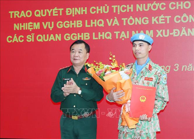Thượng tướng Hoàng Xuân Chiến, Thứ trưởng Bộ Quốc phòng trao Quyết định của Chủ tịch nước và tặng hoa cho thiếu tá Nguyễn Văn Phong trước khi lên đường sang Trung Phi thực hiện nhiệm vụ. Ảnh: Trọng Đức/TTXVN