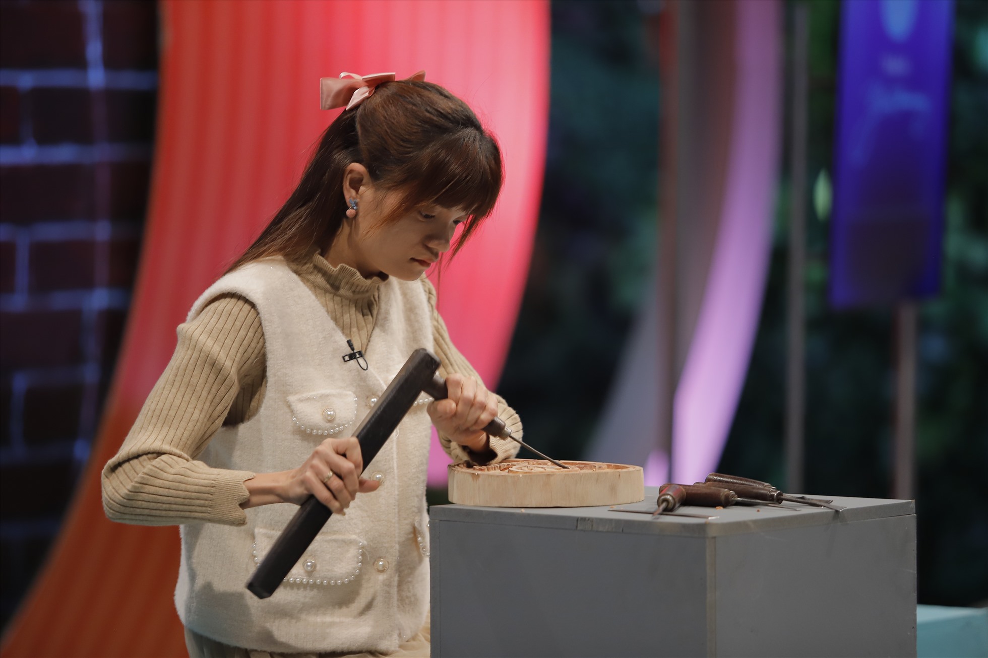Trịnh Thị Liên thể hiện tay nghề khéo léo khi chạm khắc điêu luyện logo của chương trình. Ảnh: VTV