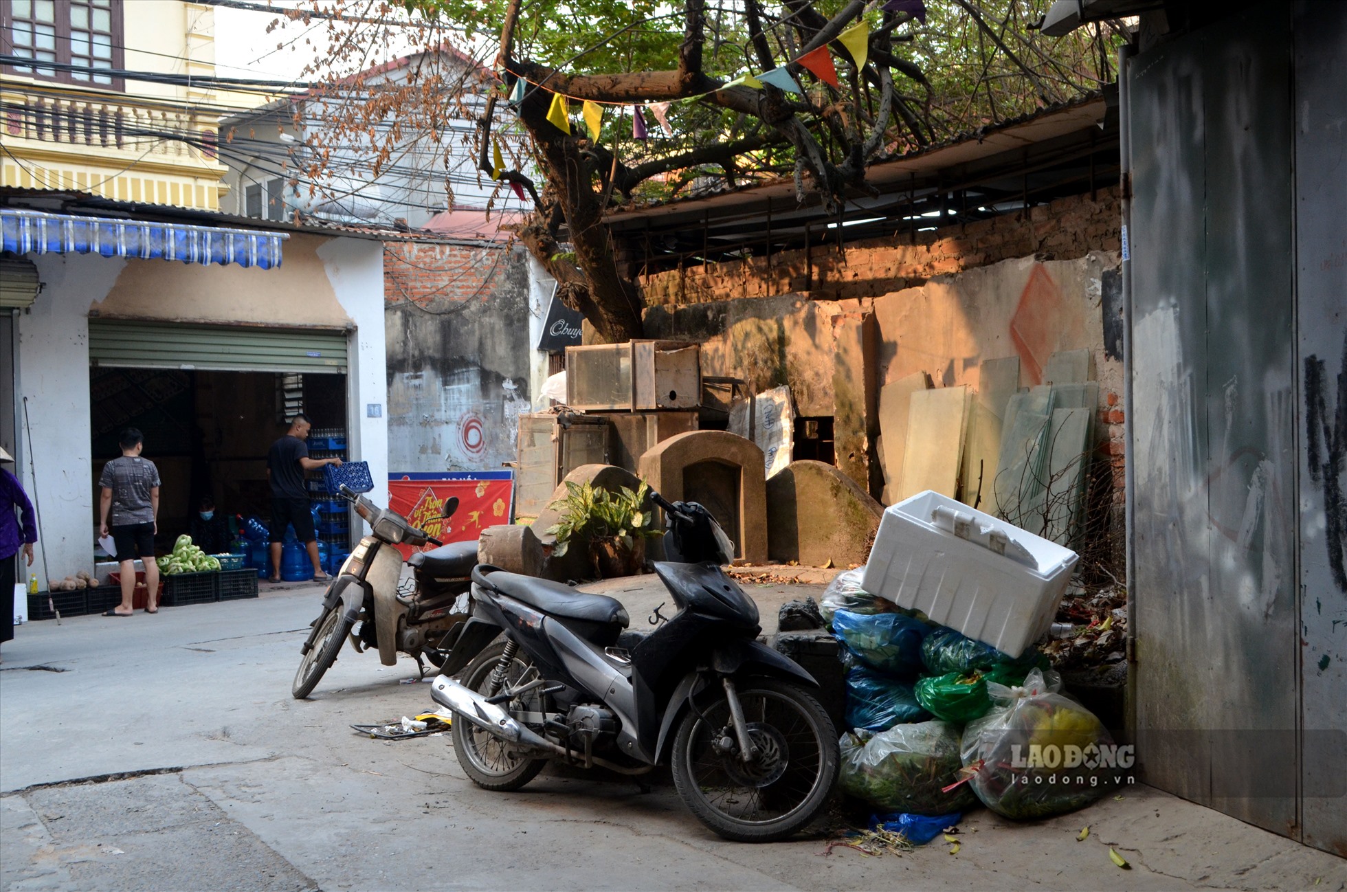 Một ngôi mộ thuộc xóm Cộng Hòa bị “bủa vây” bởi rác thải, phế liệu và xe máy.