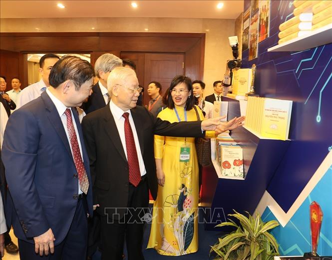 Tổng Bí thư Nguyễn Phú Trọng tham quan gian trưng bày sách tại lễ kỷ niệm. Ảnh: Trí Dũng/TTXVN