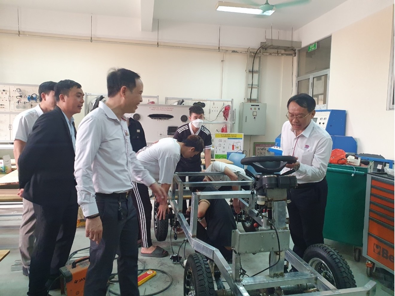 Hiệu trưởng Trường cao đẳng Công nghệ cao Hà Nội Phạm Xuân Khánh (bên phải) giới thiệu về chiếc ôtô đang được học viên lắp ráp. Ảnh: Phạm Đông