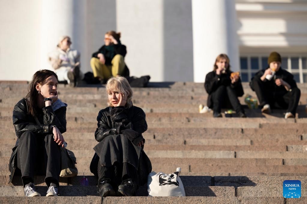 Người dân ngồi thư giãn trên bậc thang của Nhà thờ Helsinki ở Helsinki, Phần Lan, ngày 16.3.2022. Ảnh: Xinhua