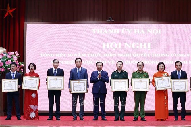 Bí thư Thành ủy Hà Nội Đinh Tiến Dũng trao tặng bằng khen tại hội nghị. Ảnh: TTXVN