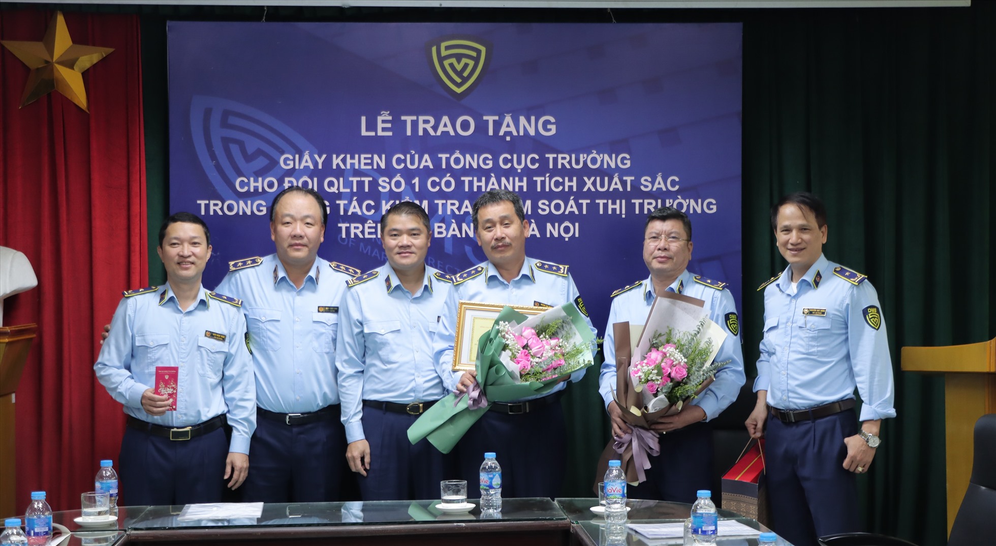 Tổng Cục trưởng Trần Hữu Linh, Phó Cục trưởng Cục QLTT TP Hà Nội Trần Việt Hùng trao tặng hoa, giấy khen và chụp ảnh lưu niệm với Tập thể Đội QLTT số 1. Ảnh. Quyên Lưu (Tổng Cục QLTT)