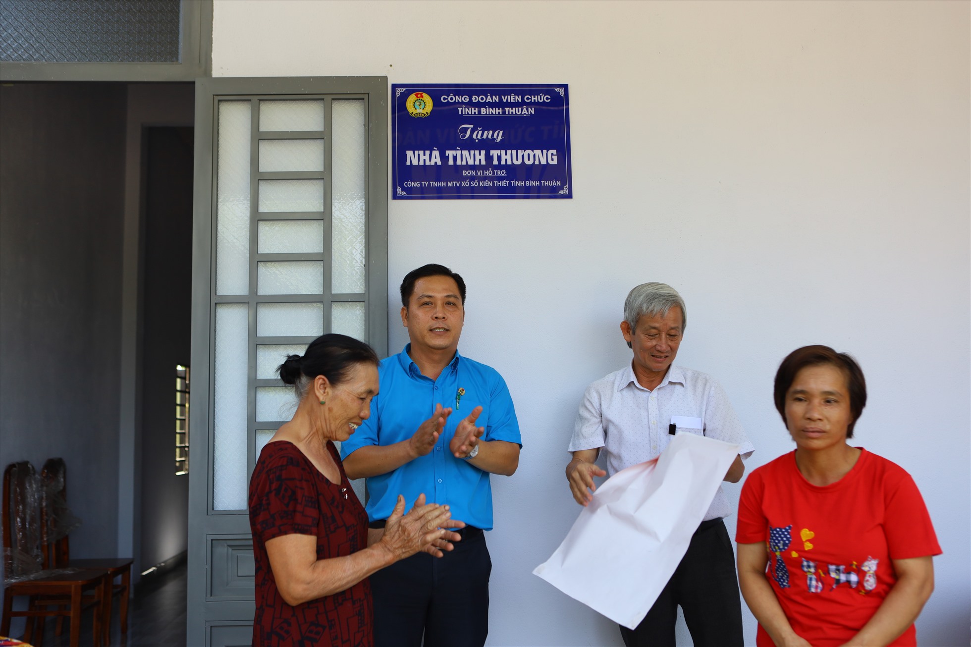 Chị Hoàng cùng gia đình vui mừng khi cùng CĐVC tỉnh Bình Thuận gỡ băng khánh thành nhà mới. Ảnh: Duy Tuấn