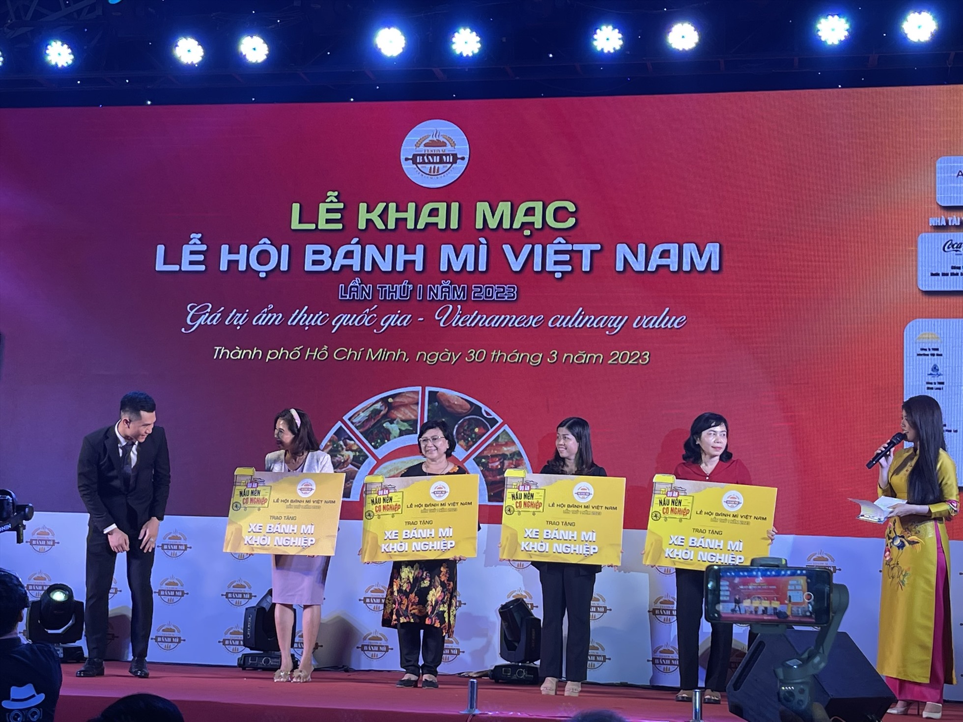 Đại diện nhà tài trợ lên trao tặng 25 xe bánh mì khởi nghiệp. Ảnh: Ngọc Ánh