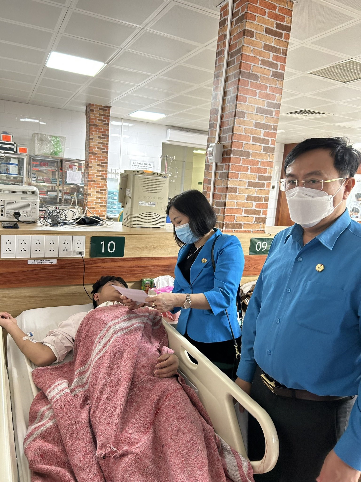 Chủ tịch Liên đoàn Lao động tỉnh Bắc Ninh Nguyễn Thị Vân Hà trao hỗ trợ cho công nhân bị ngộ độc methanol, đang được điều trị tại bệnh viện Bạch Mai. Ảnh: Ngọc An