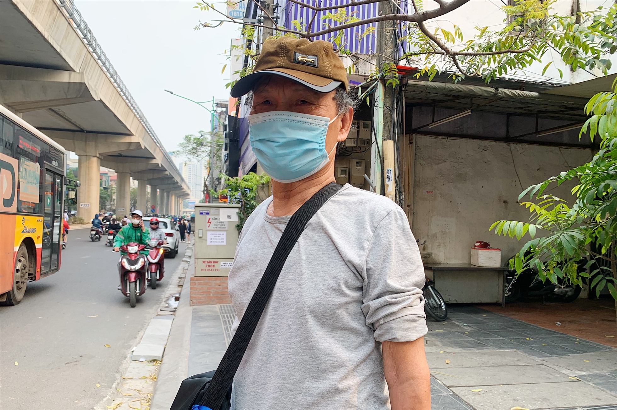 Ông Nguyễn Đinh Dương đứng đợi tuyến buýt 27 tại đường Cầu Giấy.