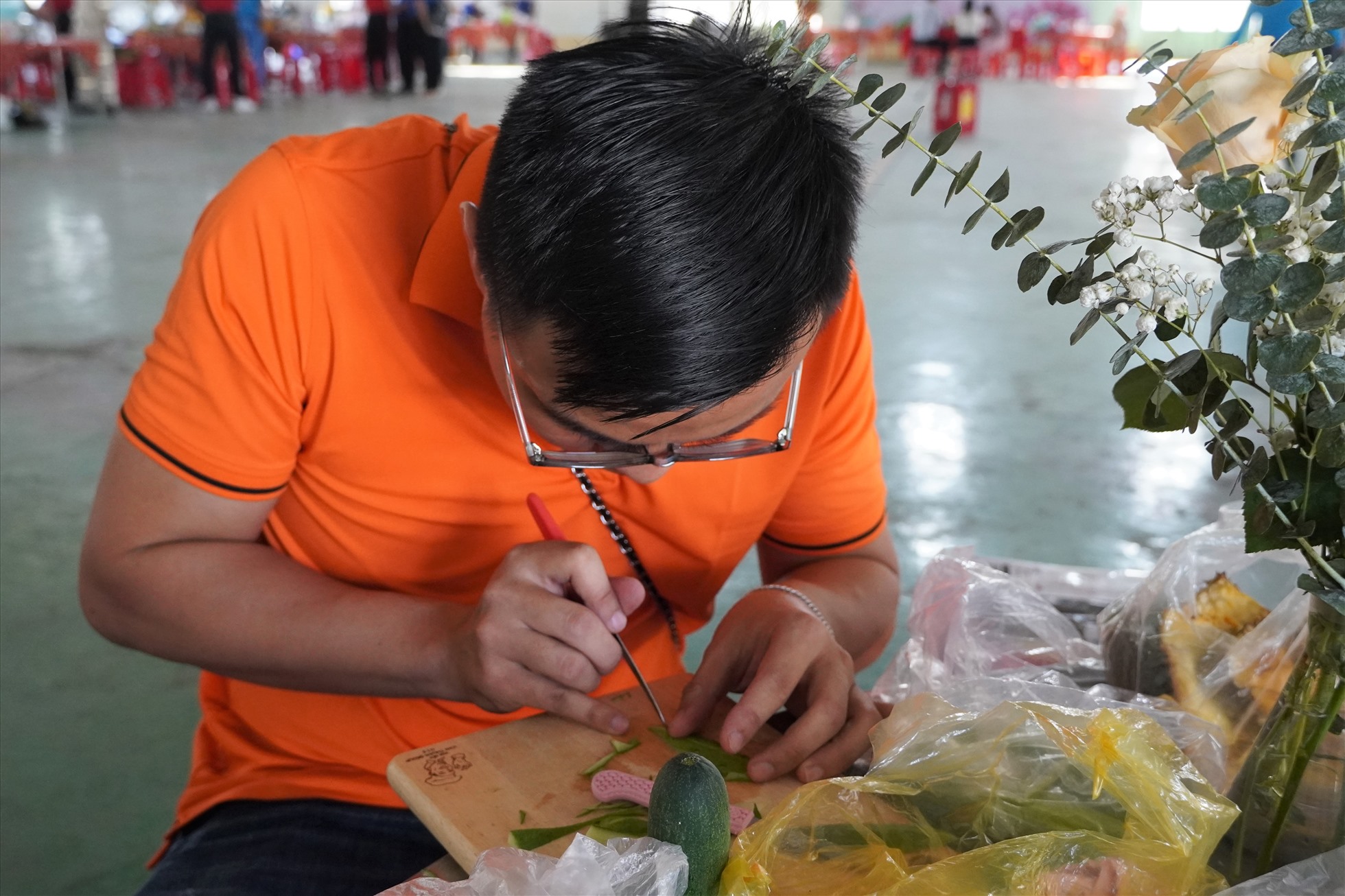 Đoàn viên Lê Duy Hải đang cặm cụi tạo hình rau củ để trang trí cho bữa ăn thêm sinh động. Ảnh: Thành An