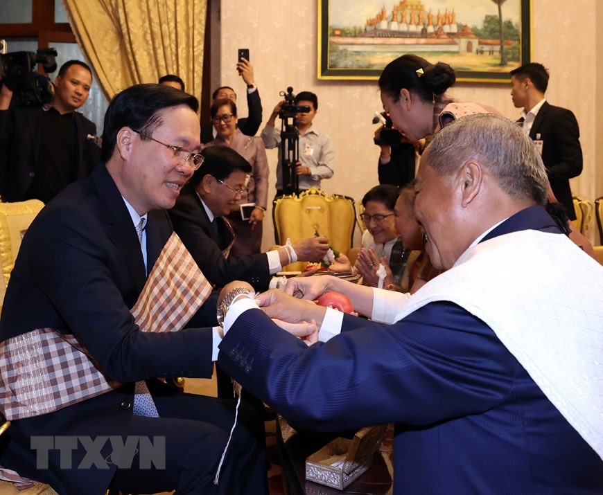 Nghi lễ buộc chỉ cổ tay cầu may cho Chủ tịch nước Võ Văn Thưởng nhân dịp Tết cổ truyền Bunpimay của Lào. Ảnh: TTXVN