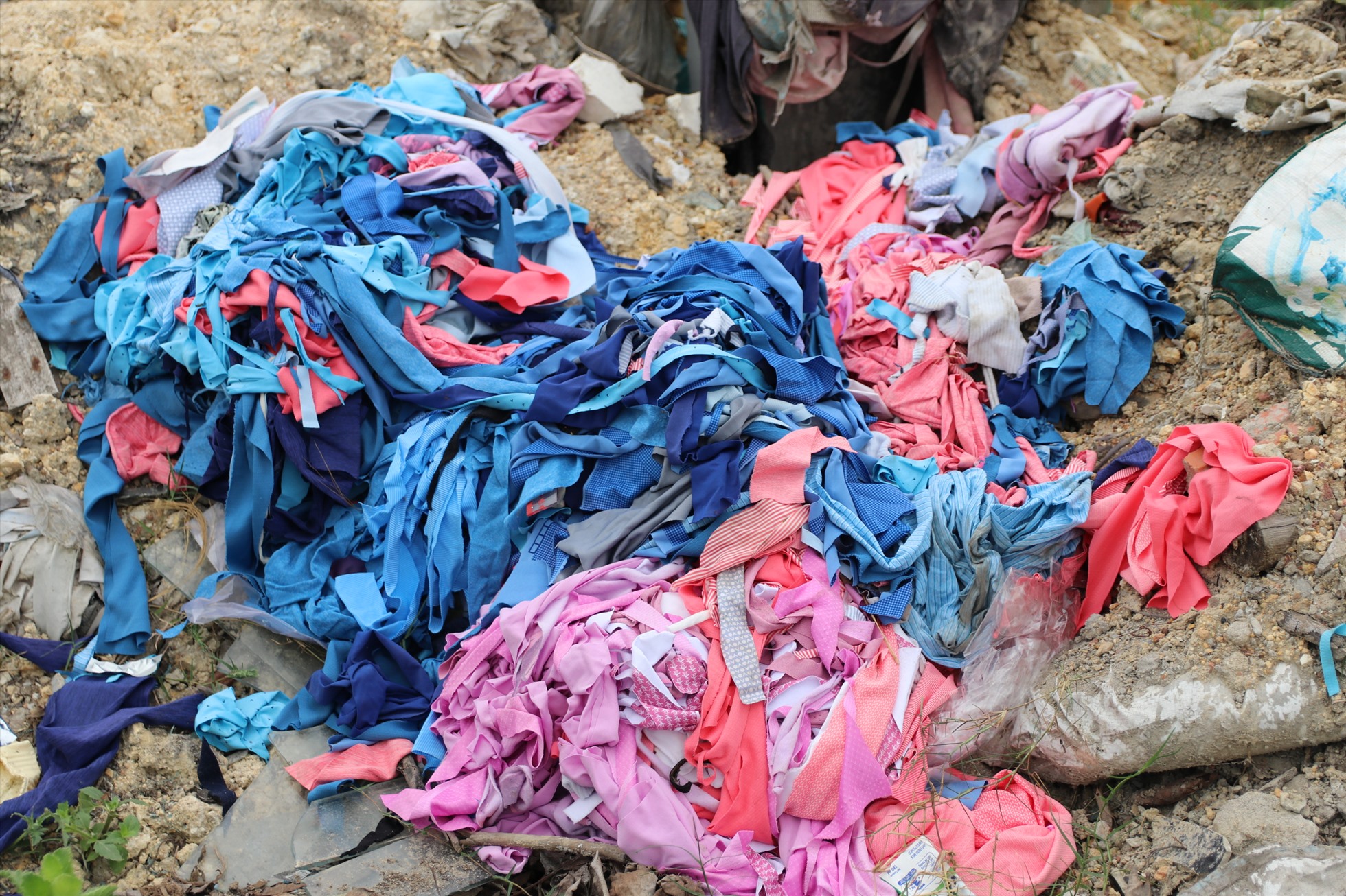 Những đống vải vụn từ các tiệm may được vứt bỏ tràn lan không có túi đựng, phó mặc cho công nhân vệ sinh môi trường.