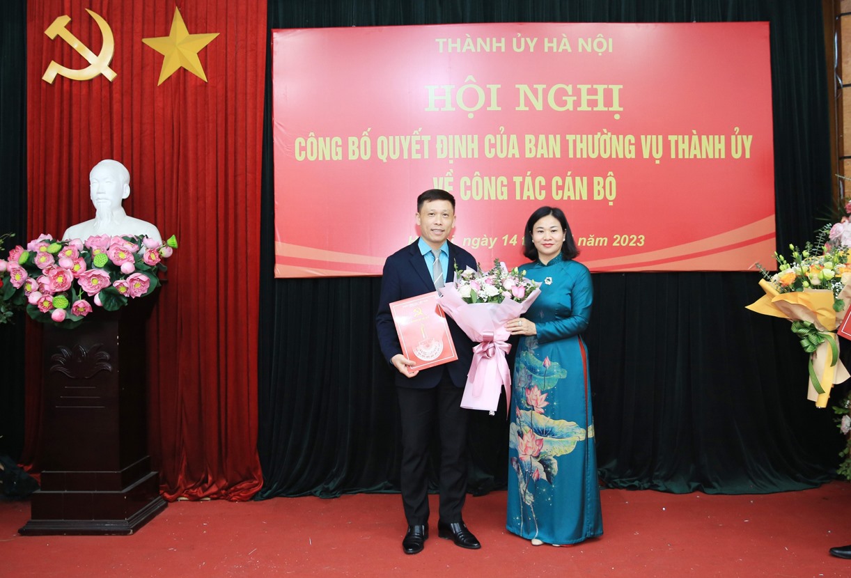 Bà Nguyễn Thị Tuyến trao quyết định của Ban Thường vụ Thành ủy và tặng hoa chúc mừng ông Nguyễn Thành Lợi. Ảnh: Quang Thái