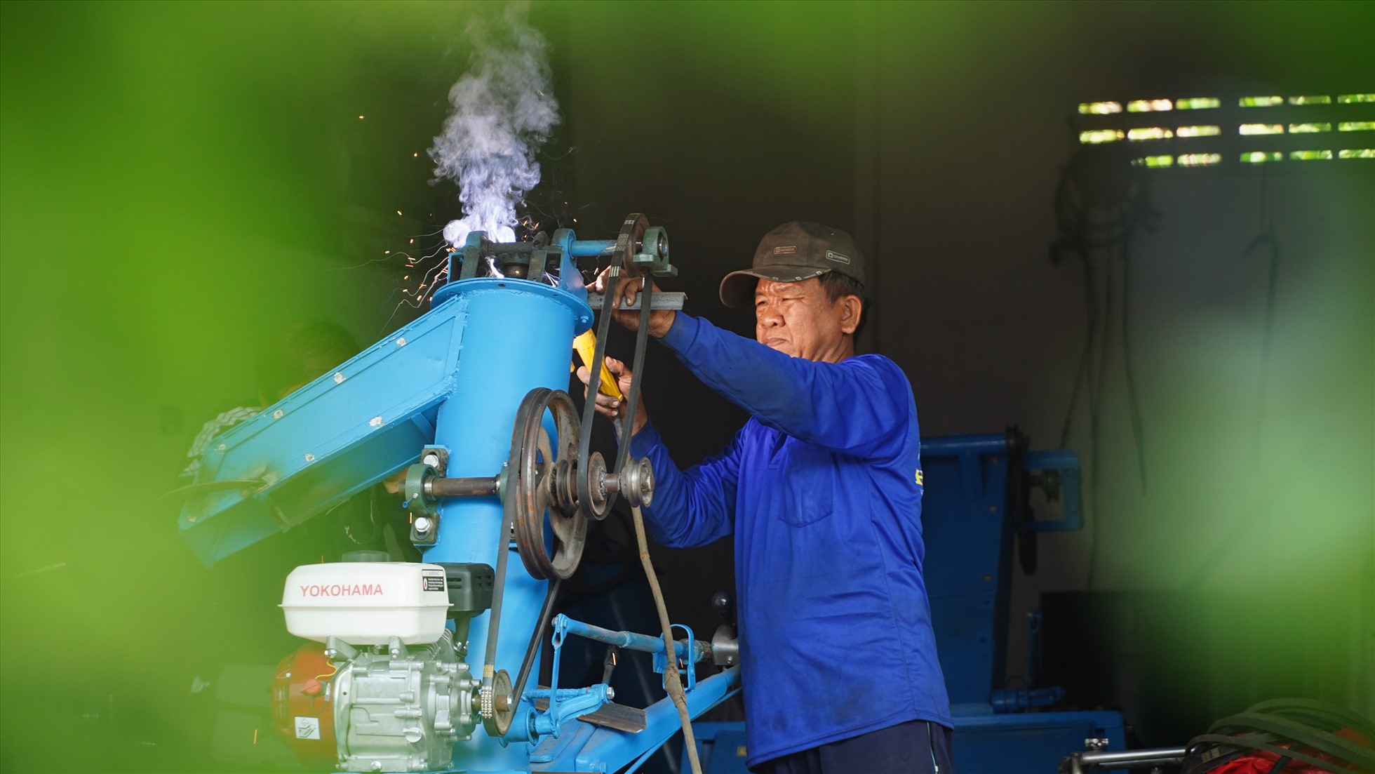 Ông Hoàng Thanh Liêm đang hàn gắn để tạo ra một chiếc máy nông nghiệp. Ảnh: Tạ Quang