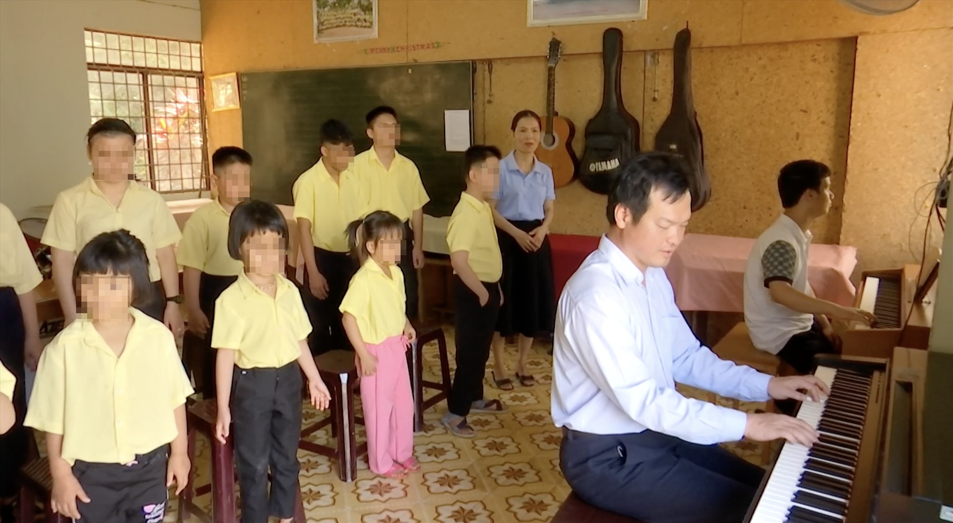 Anh Lê Hoàng Gia Hưng dạy nhạc cho các em nhỏ. Ảnh: Bảo Trung