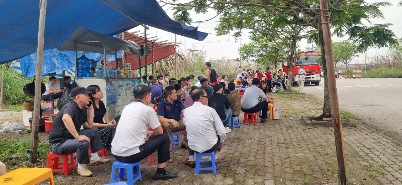 Người dân ngồi ngoài đường theo dõi phiên tòa. Ảnh: Nguyễn Hùng