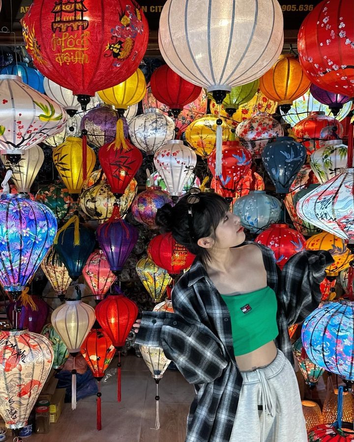 Nữ ca sĩ chụp ảnh bên một tiệm bán đèn lồng ở Hội An, Quảng Nam.
