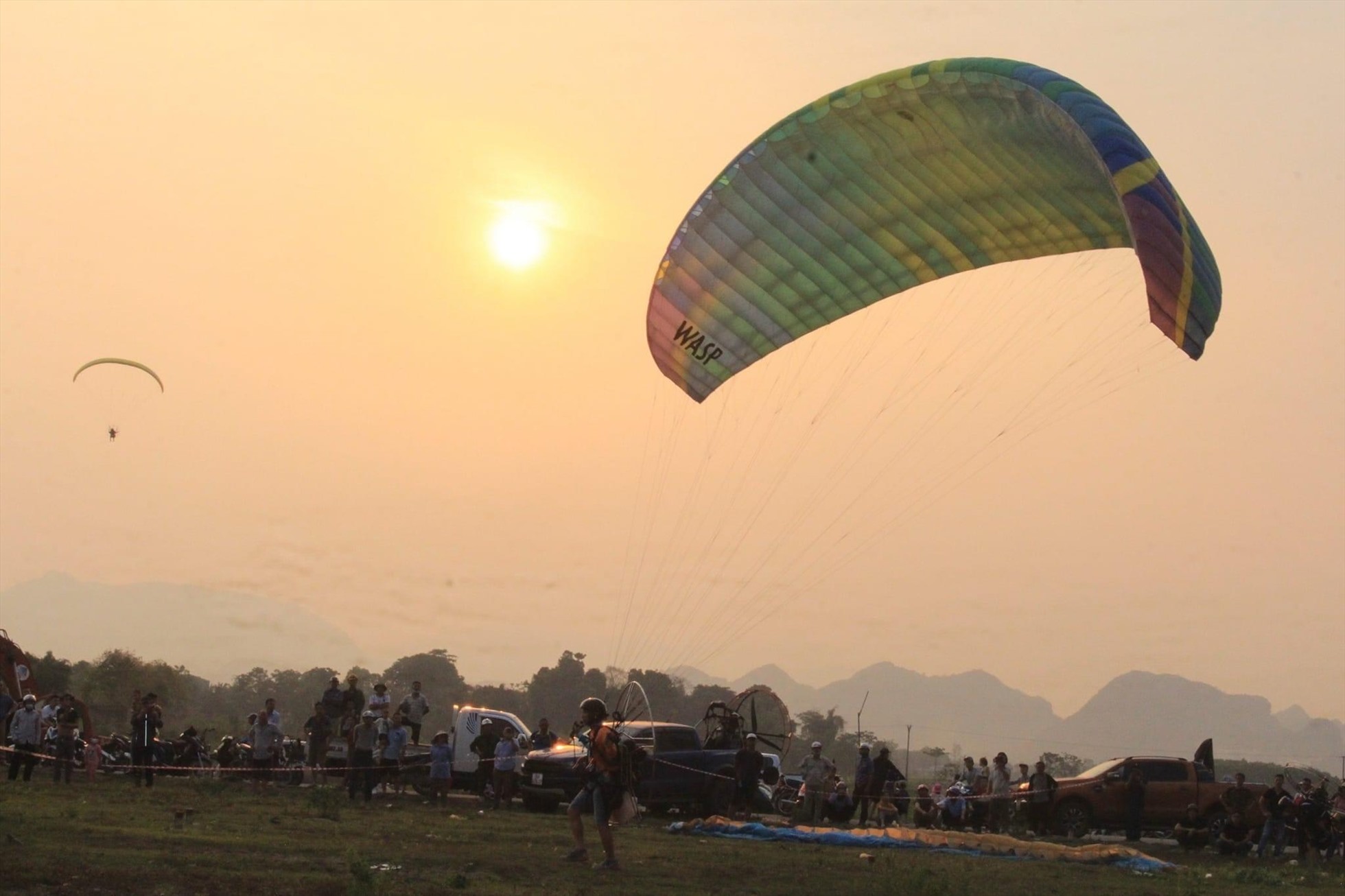 Khác với dù lượn thông thường (paragliding), dù lượn động cơ (paramotor) sử dụng động cơ cánh quạt sau lưng, giúp người chơi có thể bay lên từ đất bằng, mà không cần phải có đồi núi, tời kéo, không phải phụ thuộc vào gió hay luồng khí nóng. Ảnh: Quỳnh Trang