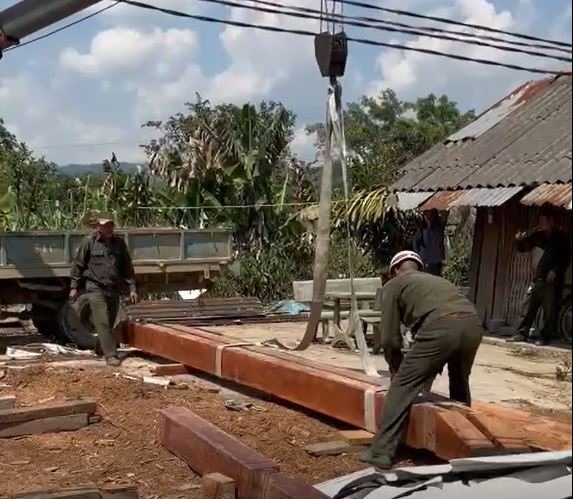 Lực lượng chức năng huyện Ea Kar giúp người dân dựng nhà cửa ở khu tái định cư số 2. Ảnh: Bảo Trung