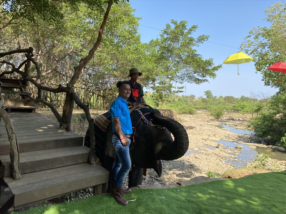 Một du khách thích thú khi được chụp ảnh lưu niệm cùng voi. Ảnh: Bảo Trung
