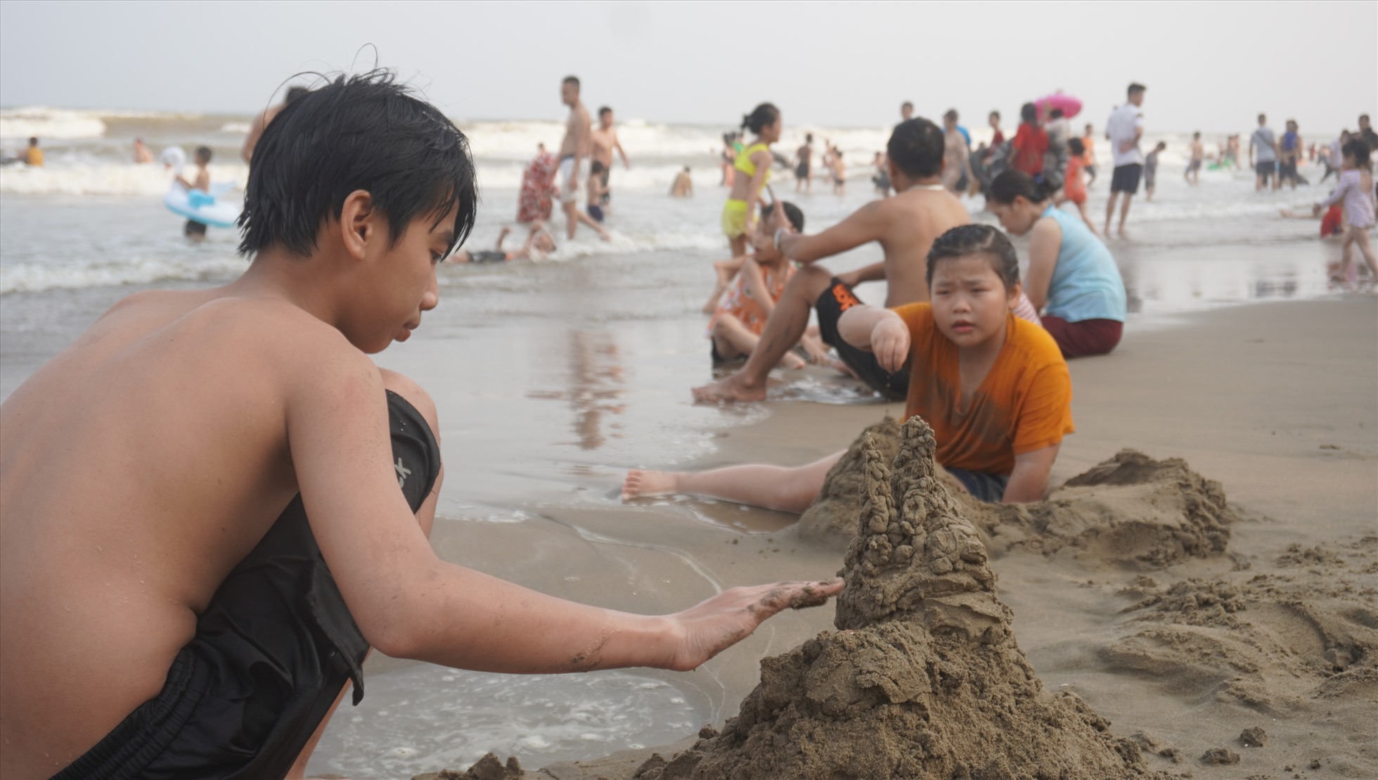 Trẻ nhỏ cùng gia đình đi nghỉ mát, tỏ ra thích thú nô đùa trên bãi cát. Ảnh: Quách Du