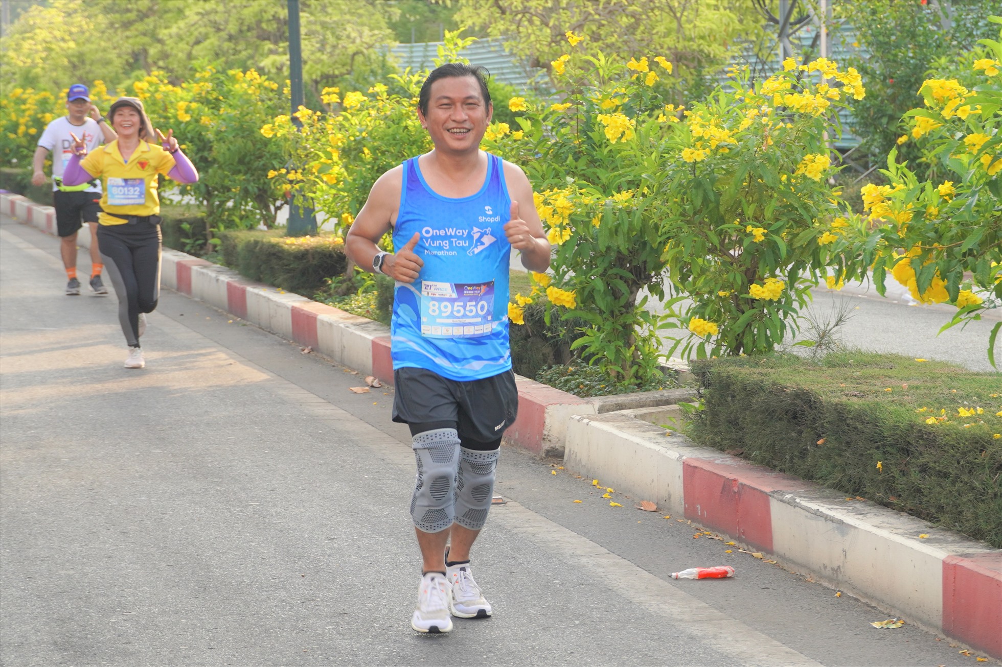 Vận động viên vẫn vui vẻ phấn khởi trên cung đường hoa giấy, hoa chuông vàng dài nhất Việt Nam sau khi hoàn thành 13/21 km. Ảnh: Thành An