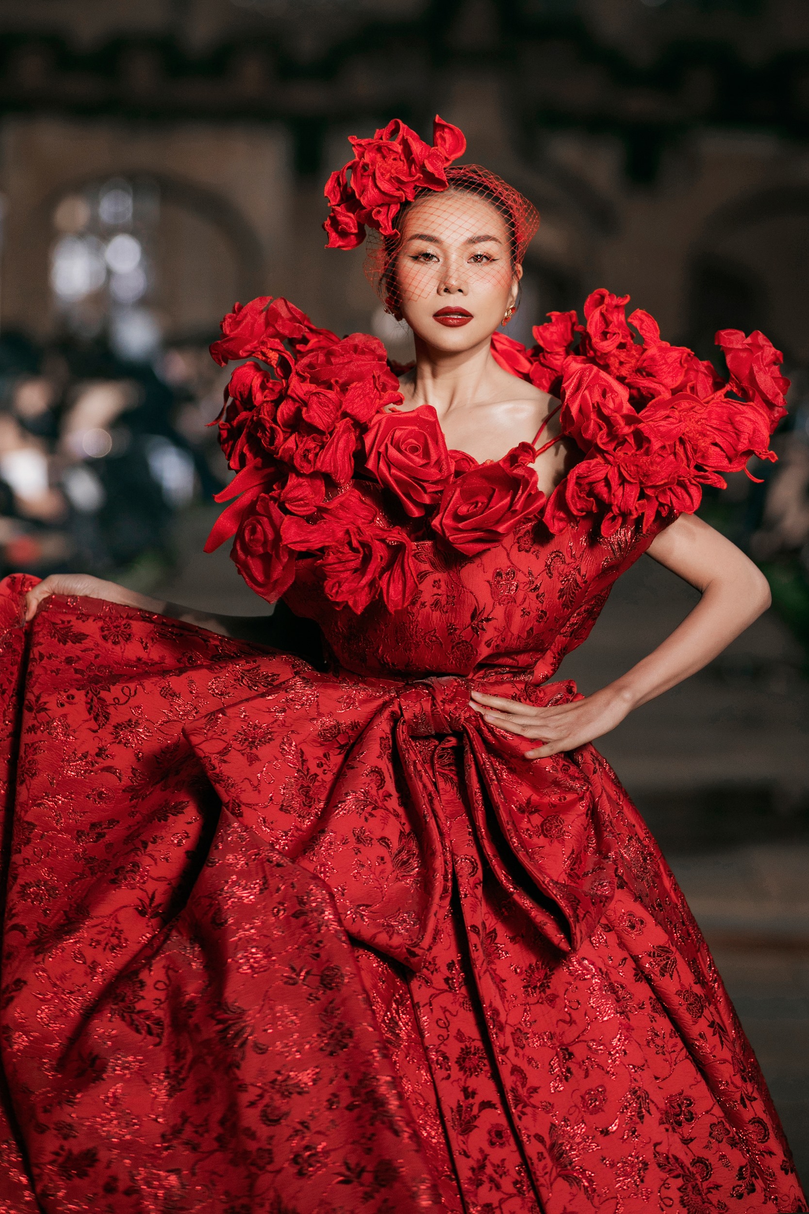 Siêu mẫu Thanh Hằng trình diễn thiết kế màu đỏ nổi bật nặng đến 15 kg với điểm nhấn là phần bèo nhún tinh xảo ở phần vai áo trông như những nụ hoa đang bung nở. Ảnh: Kiếng Cận
