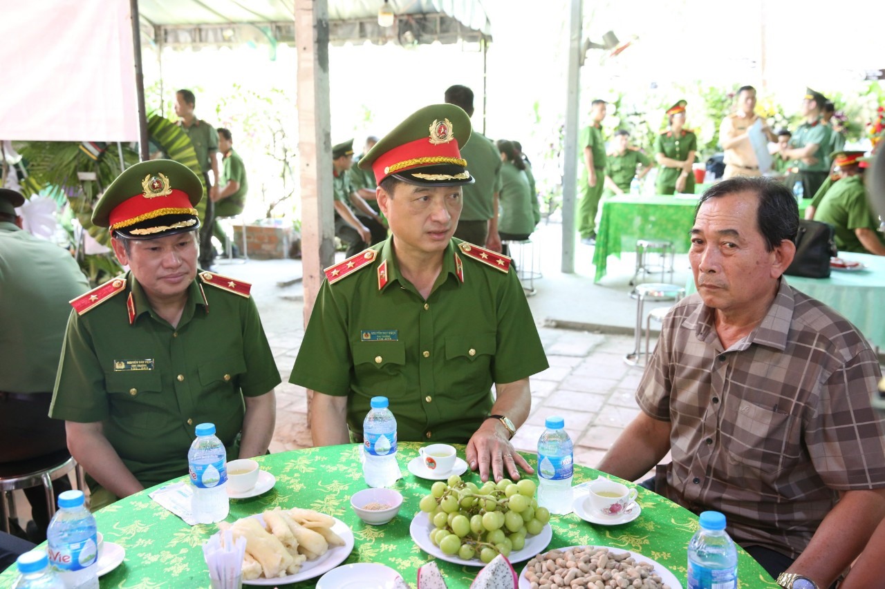 Thứ trưởng Nguyễn Duy Ngọc thăm hỏi, động viên ông Nguyễn Văn Dư (cha của Trung tá Hào). Ảnh: An Long