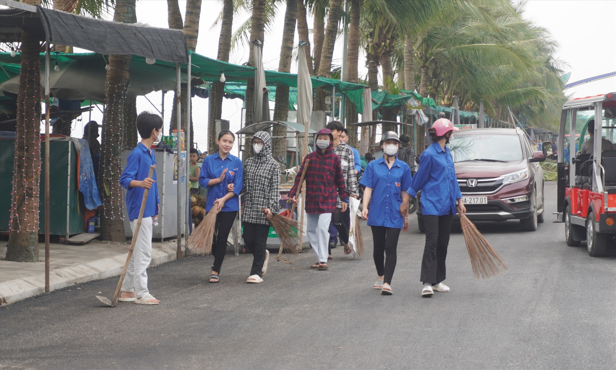 Thanh niên tình nguyện tiến hành dọn, quét rác dọc các tuyến đường ở biển Hải Tiến. Ảnh: Quách Du