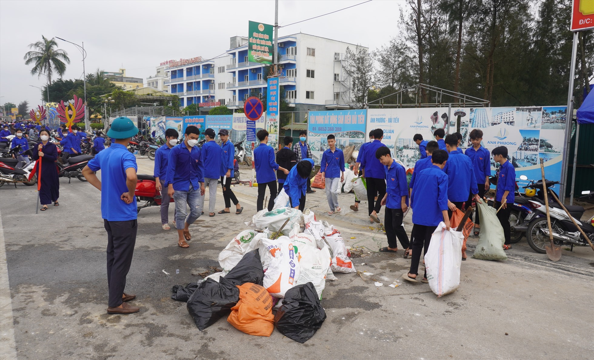 Thanh niên tình nguyện tiến hành dọn, quét rác dọc các tuyến đường ở biển Hải Tiến. Ảnh: Quách Du