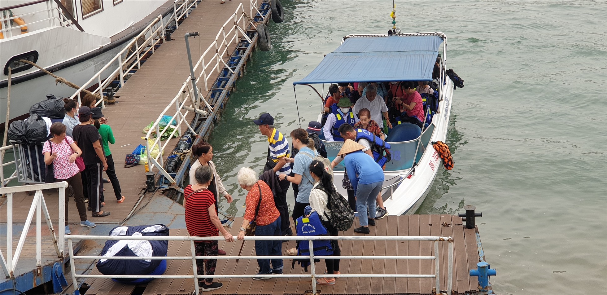 Du khách nghỉ đêm trên vịnh Lan Hạ vừa được một chiếc tender đón từ tàu du lịch đang neo đậu trên vịnh Lan Hạ trở về Cảng tàu Tuần Châu. Ảnh: Nguyễn Hùng