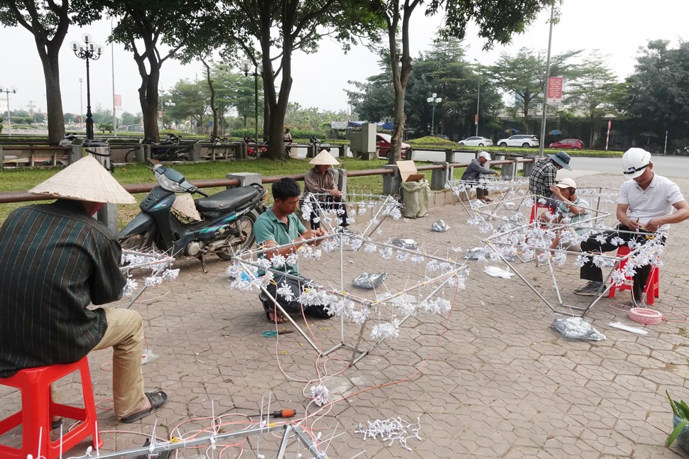 Những người thợ đang khẩn trương chuẩn bị các giàn đèn nháy để trang trí. Ảnh: Trần Tuấn.