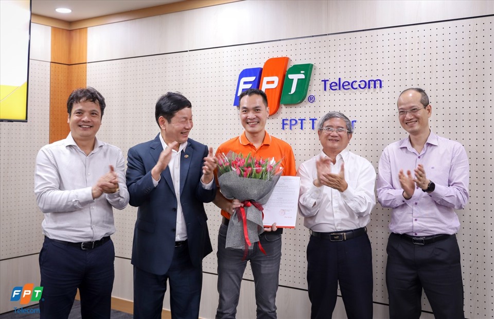 Tân Tổng giám đốc FPT Telecom ông Nguyễn Hoàng Linh (giữa) nhận quyết định và hoa chúc mừng từ ban lãnh đạo tập đoàn. Ảnh: FPT