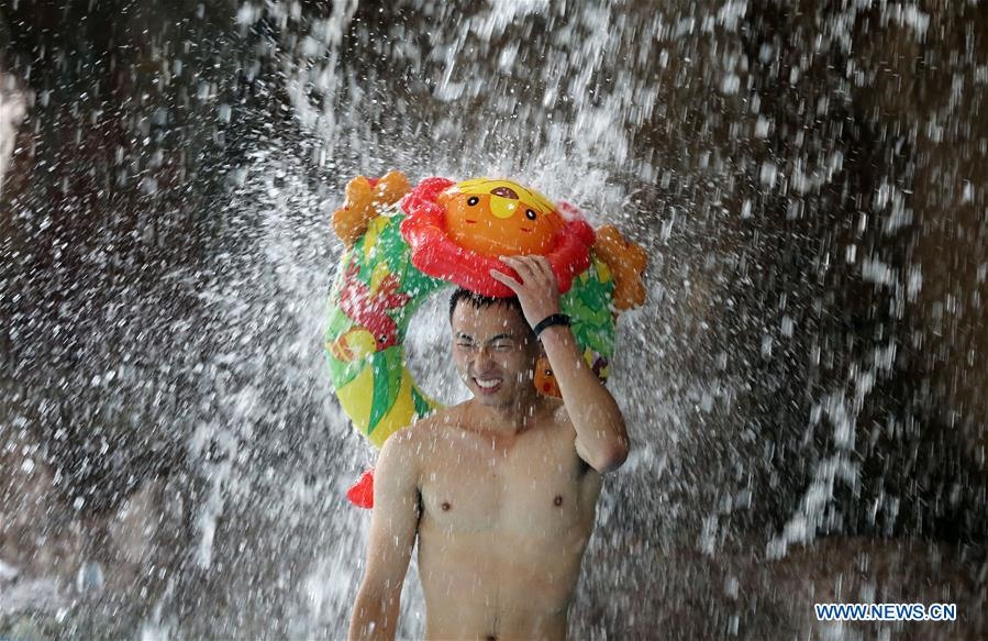 Một người đàn ông trong công viên giải trí dưới nước ở tỉnh Sơn Đông của Trung Quốc trong đợt nắng nóng mùa hè năm 2018. Ảnh: Xinhua