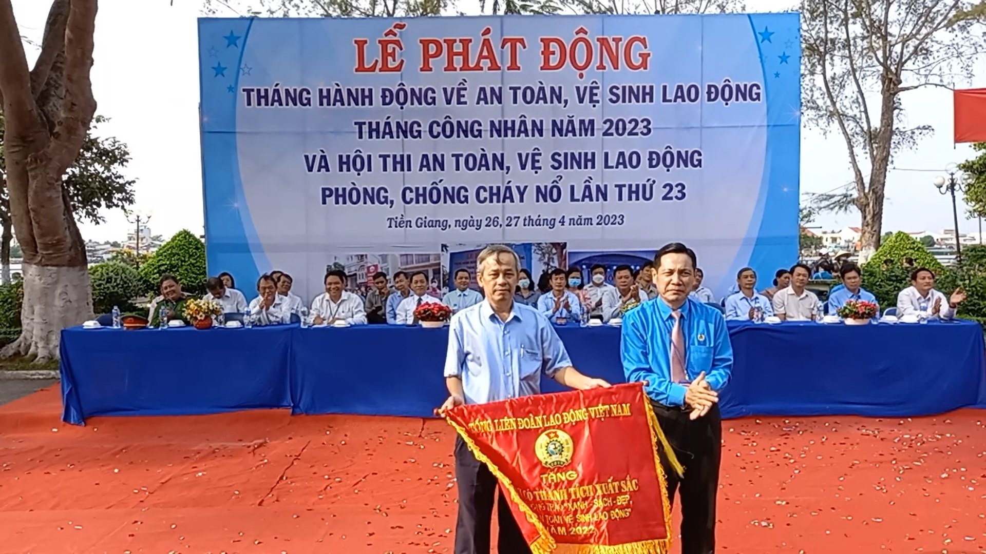 Chủ tịch LĐLĐ tỉnh Tiền Giang Lê Minh Hùng - trao cờ thi đua của Tổng LĐLĐ Việt Nam cho tập thể