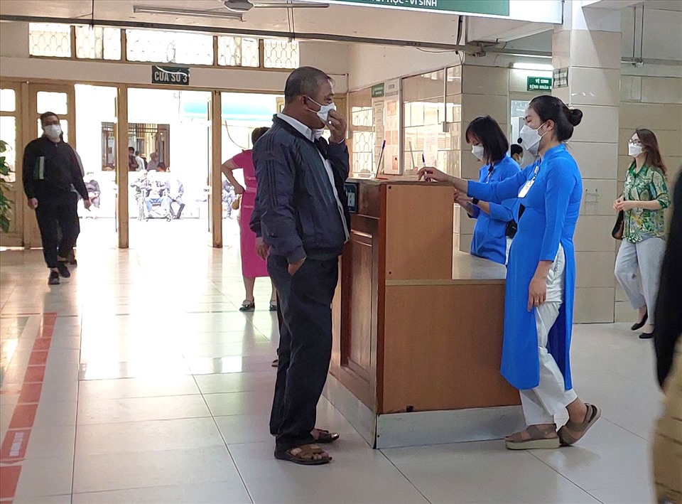 Nhân viên tiếp đón của bệnh viện thường xuyên nhắc nhở người đến khám bệnh đeo khẩu trang theo quy định.