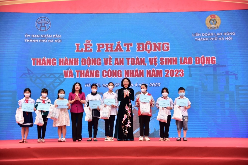 Bà Nguyễn Thị Hà - Thứ trưởng Bộ LĐ-TB&XH (áo hồng) và bà Vũ Thu Hà - Phó Chủ tịch UBND Thành phố trao quà cho con đoàn viên công đoàn có hoàn cảnh khó khăn, bị tai nạn lao động.