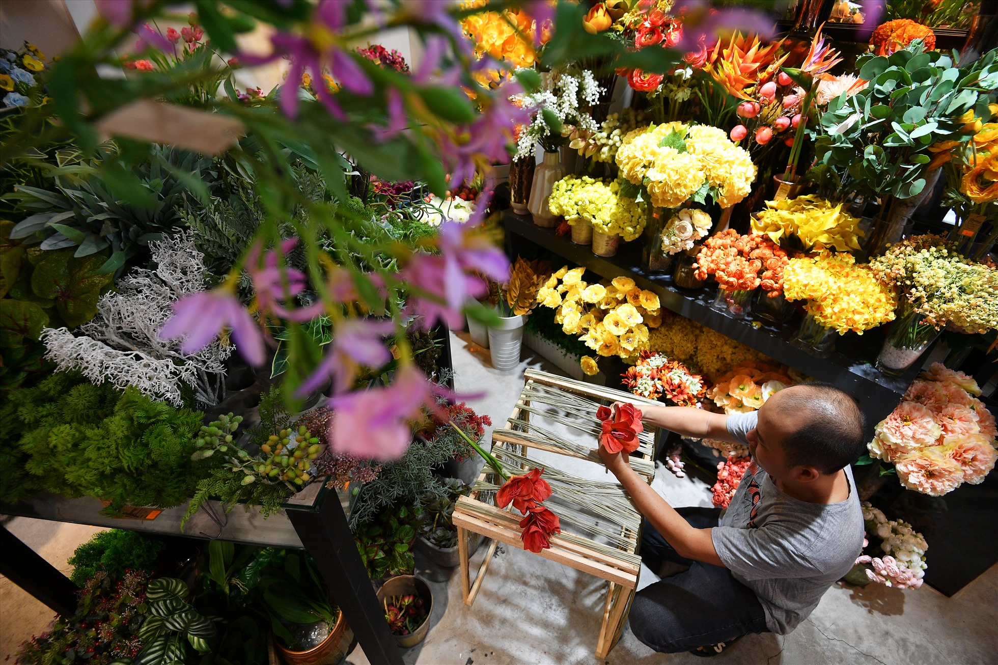Tô Duy Kha, một nghệ nhân thiết kế hoa có tiếng ở Sài Gòn đang thực hiện tác phẩm hoa.