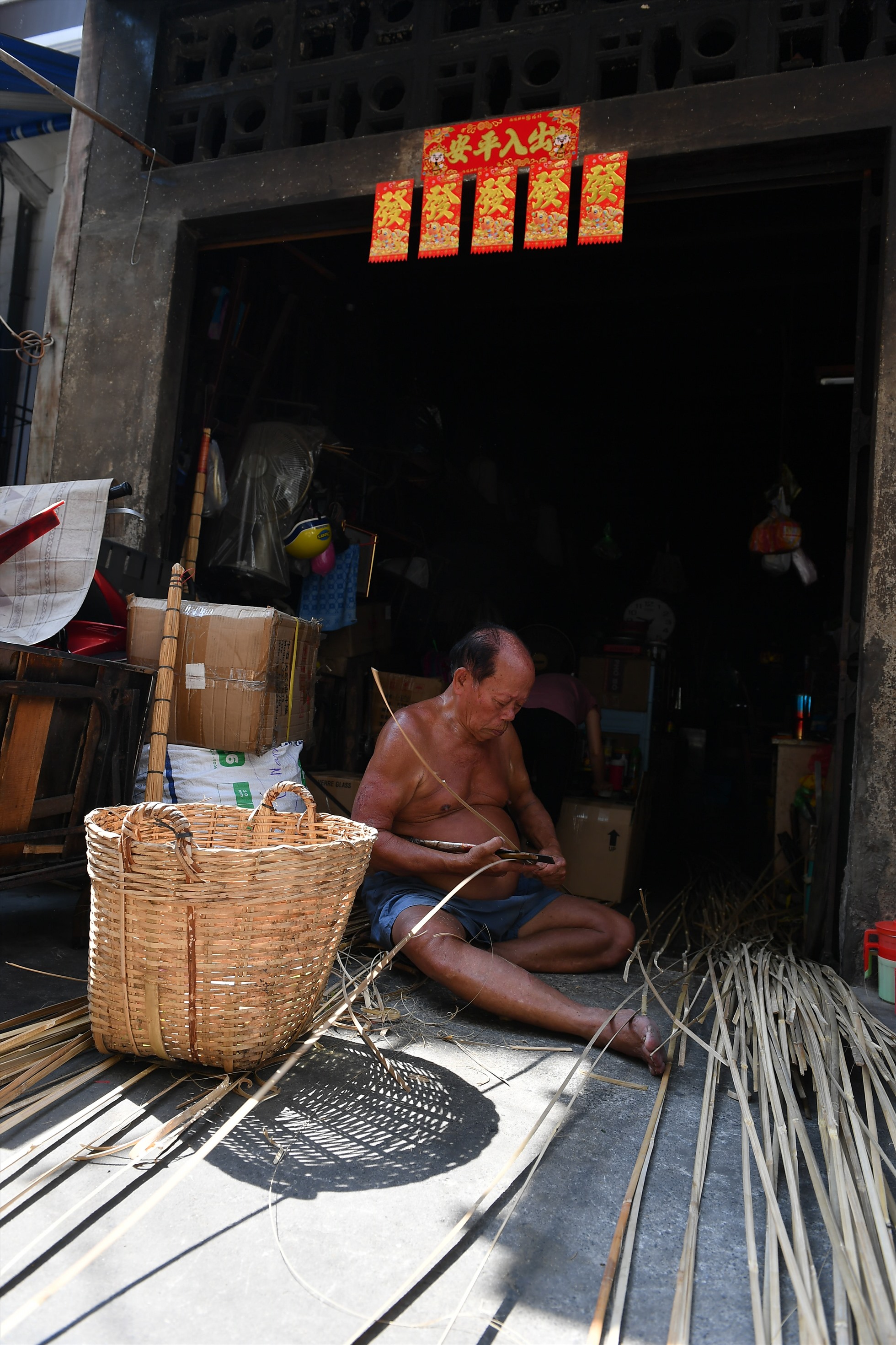 Ông Tào Quốc Lương, sống ở Quận 5, 76 tuổi, đang miệt mài đan giỏ tre.