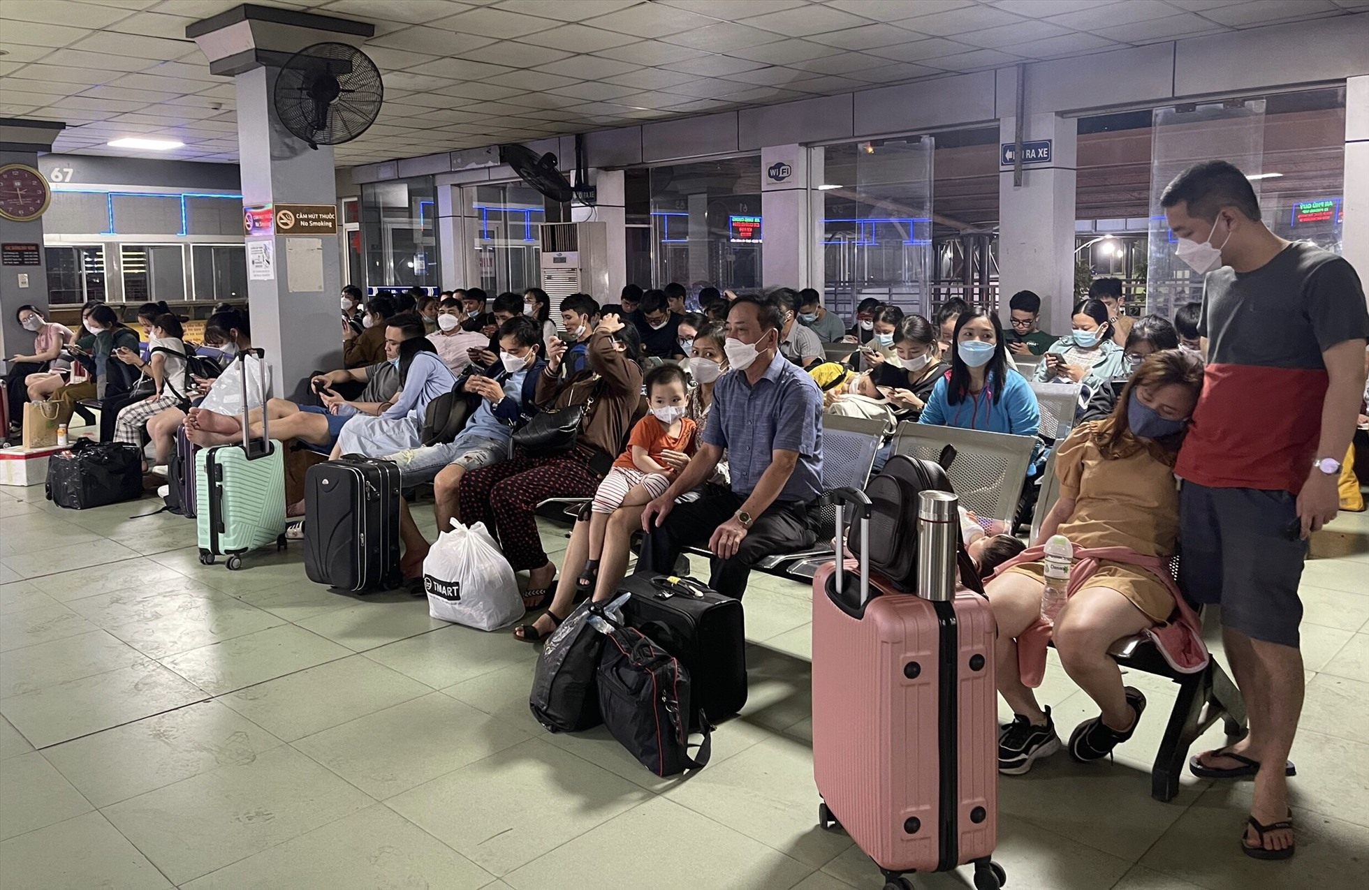 Nhiều người dân mệt mỏi mua vé và chờ đợi xe xuất bến ở Bến xe Nước Ngầm tối muộn 28.4. Ảnh: Hữu Chánh