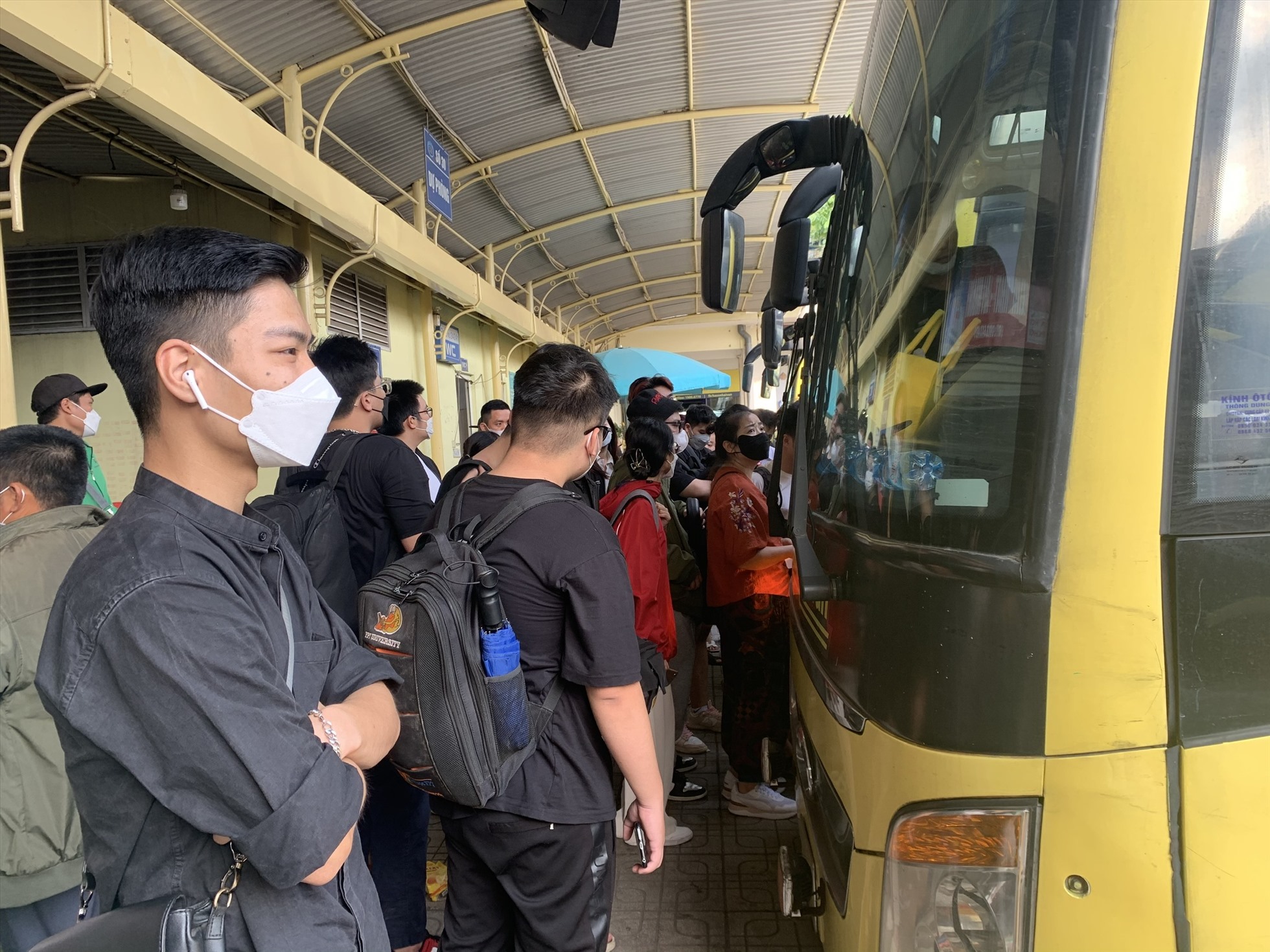 Việt Hoàng cùng nhiều hành khách chờ đợi chuẩn bị lên xe khách. Ảnh: Trần Vương